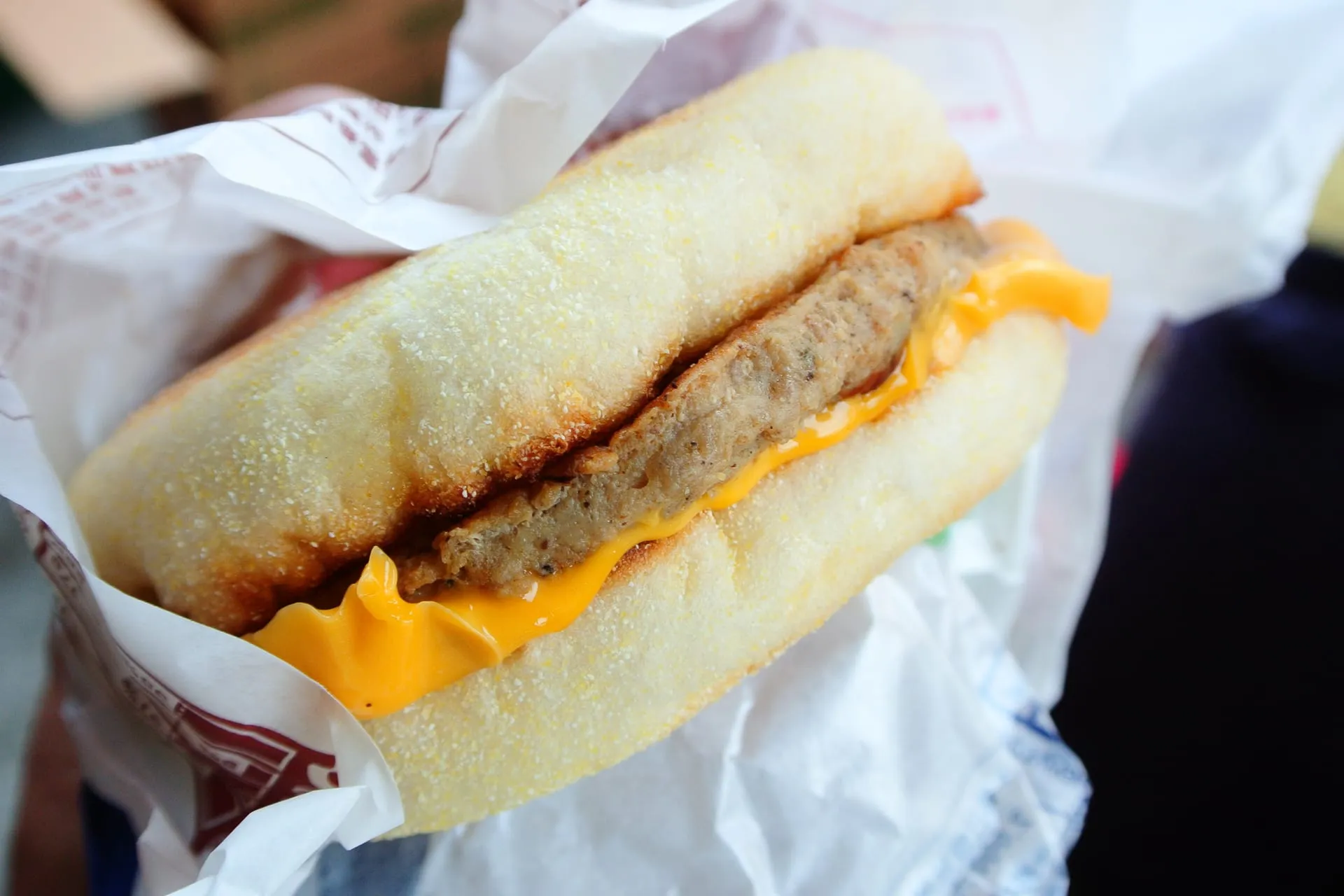 A Sausage McMuffin held in its paper wrapper